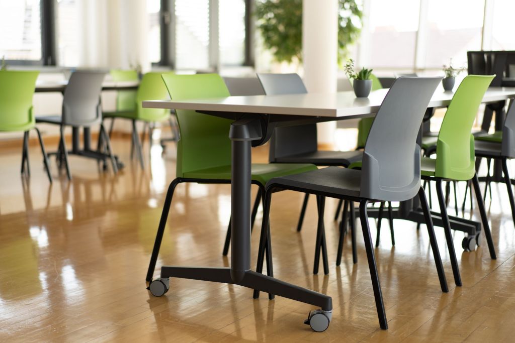 Work-Café mit mobilen Tischen und bunt gemischten Stühlen
