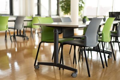 Work-Café mit mobilen Tischen und bunt gemischten Stühlen