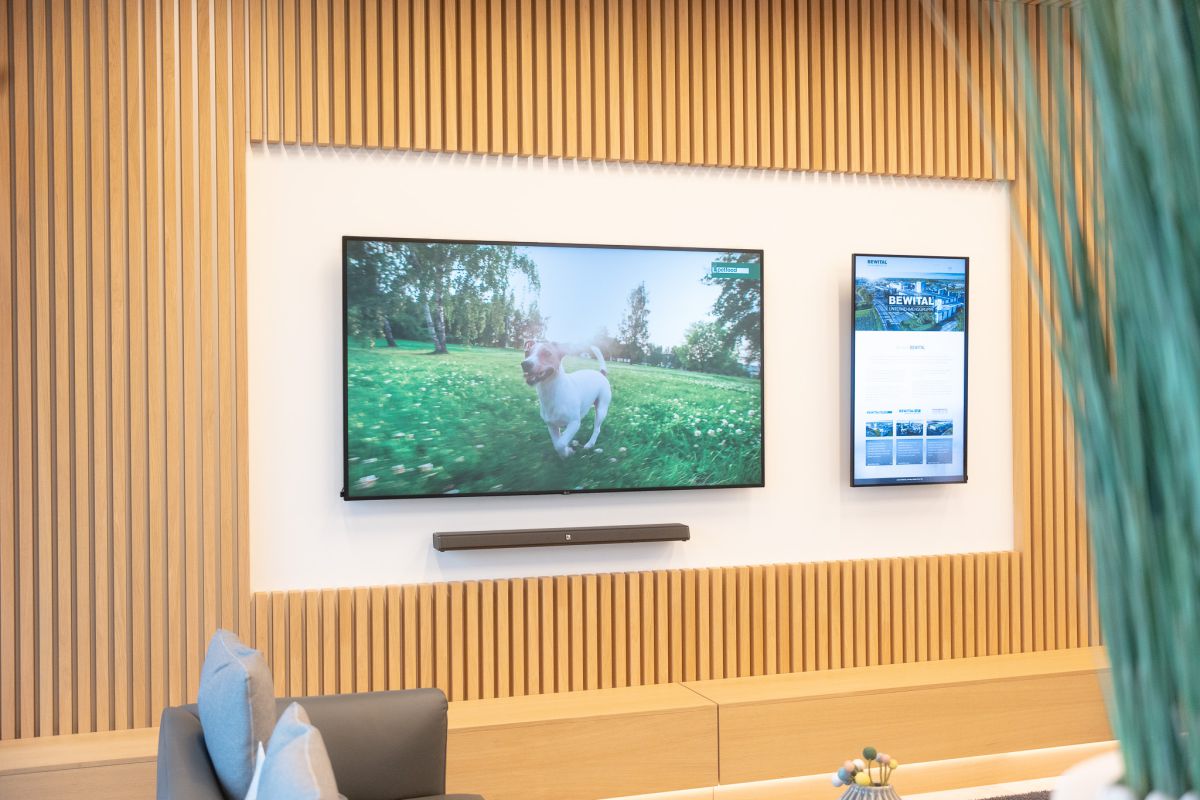 Die repräsentative Wartezone im Eingangsbereich beeindruckt Besucher:innen mit einer integrierten Videowand