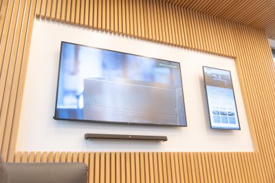 Die repräsentative Wartezone im Eingangsbereich beeindruckt Besucher:innen mit einer integrierten Videowand