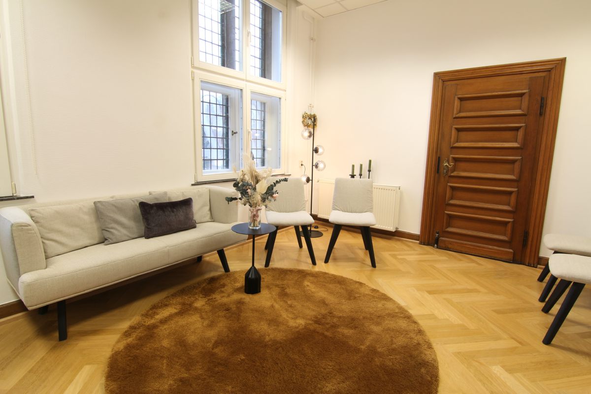 Geradlinges Sofa in Kombination mit minimalistischen Stühlen in Beigetönen im skandinavischen Wohnzimmerlook