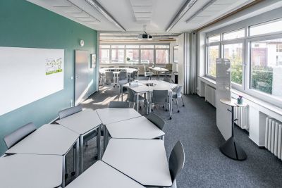 Ein Schulungsraum mit mobilen Einzeltischen in Sitzhöhe die bei Bedarf zusammengeschoben und gemeinsam genutzt werden