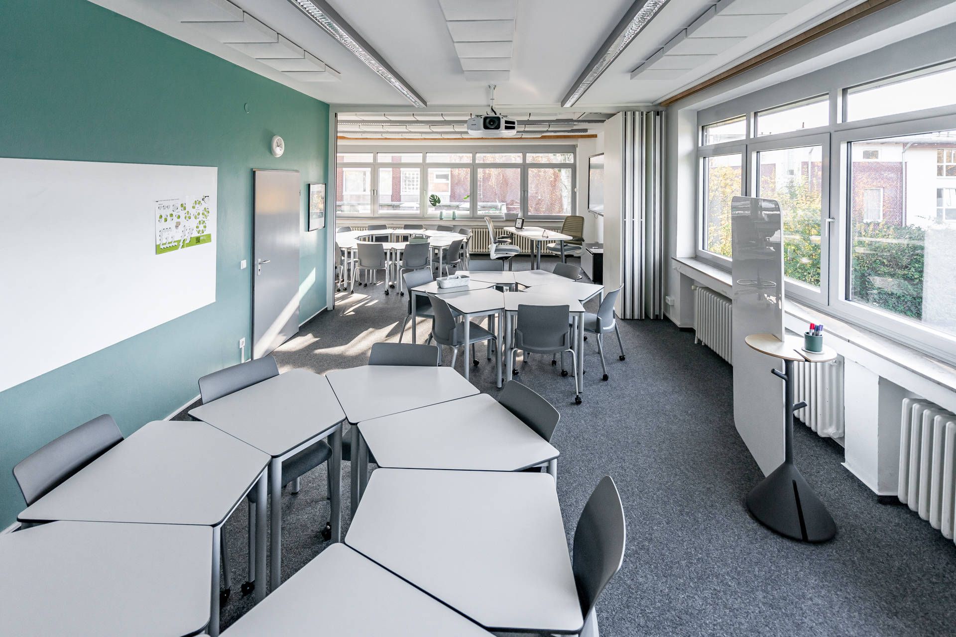 Ein Schulungsraum mit mobilen Einzeltischen in Sitzhöhe die bei Bedarf zusammengeschoben und gemeinsam genutzt werden